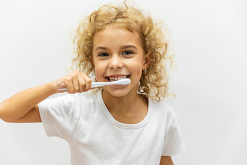 Happy smiling child kid girl brushing teeth with toothbrush on white background. Health care,...
