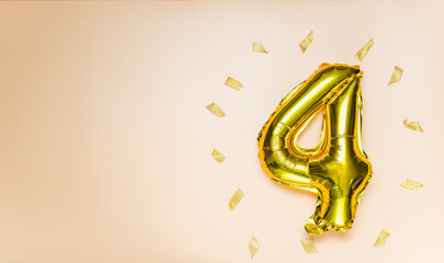A balloon made of gold foil with the number four. A birthday or anniversary card with the...