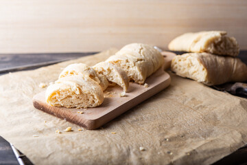 Fresh homemade bread, cut into slices on wooden cutting board. Fragrant bread with crunchy crust and soft inside.