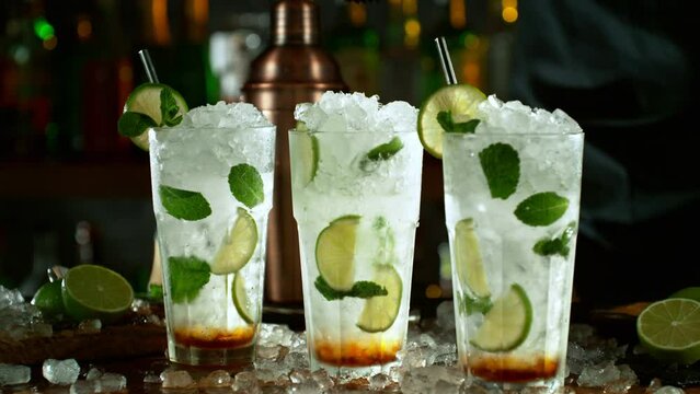 Super slow motion of preparing mojito drink swith speed motion. Filmed on high speed cinema camera, 1000 fps, placed on high speed cine bot. Bar with bottles on background.