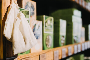 Eco-Friendly Products on Wooden Store Shelves. Reusable fabric pouch hanging beside green packaged...