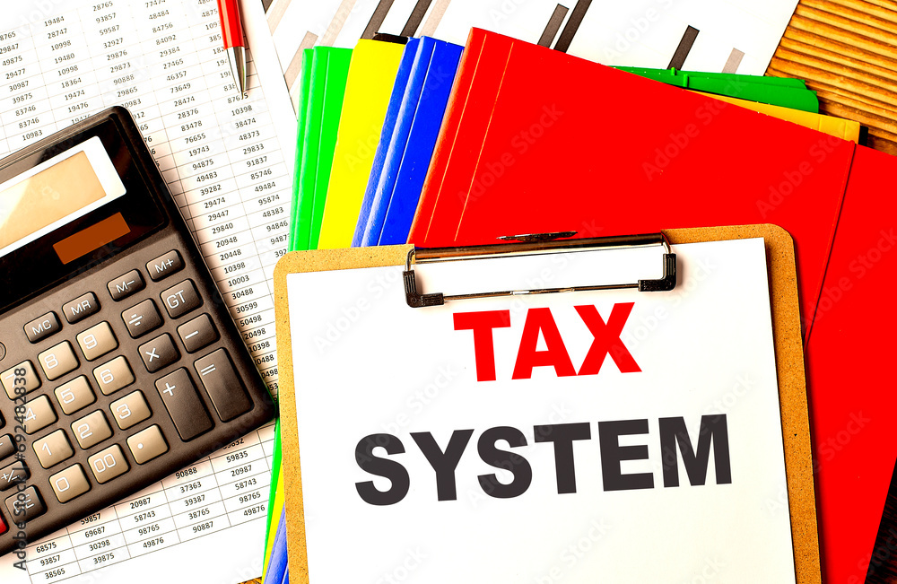 Poster tax system text written on paper clipboard with chart and calculator