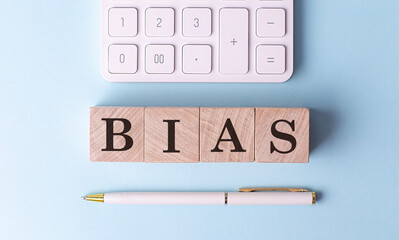 BIAS on wooden cubes with pen and calculator, financial concept