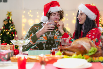 Young adult family celebrating xmas Christmas thanksgiving together in dining room with yummy roasted turkey and wine. People celebrate tradition christmastime with delicious good taste chicken party