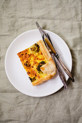Sliced traditional french open quiche pie with cheese and broccoli