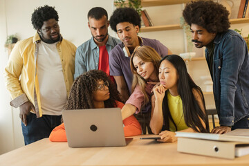 group of multiracial young people brainstorming in front of their laptop for their classes while...