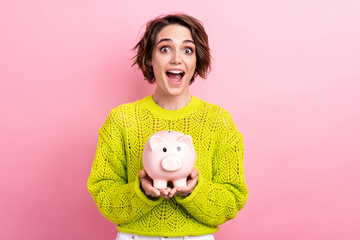 Fototapeta na wymiar Conceptual photo of young amazed funny girl shocked celebrate finish dream achievement hold piggy bank isolated on pink color background