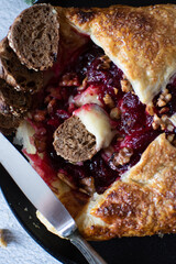 Baked brie cheese and cranberry puff pastry. Homemade puff pastry baking, sweet-savory taste, gourmet appetizer.