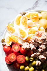 Nicoise Salad - French style salad with eggs, tuna, tomatoes, green olives, potatoes, green beans and cucumber