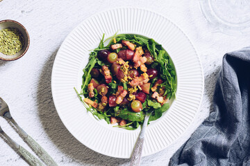 Tasty salad with arugula, grapes, bacon and fennel seeds