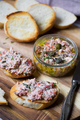Salmon rillettes, mousse, pate and toasts on wooden background