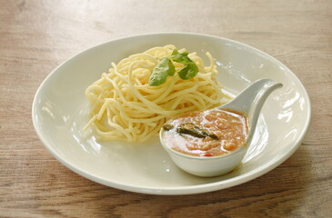 boiled spaghetti dressing spicy fried chop chicken with chili and basil sauce on plate  