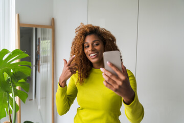 Multiracial happy woman video calling smartphone and looking away