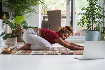 Full length photo of african american calm woman standing and doing yoga balance