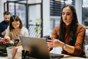 Colleagues analyzing reports and sales statistics in a creative office. Small business start-up team working together on market analysis and profit growth.