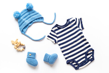 Set of baby boy dress - blue bodysuit with knitted hat and boots, top view. Kids clothing flat lay