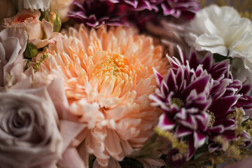 Fototapeta premium Detail close up of chrysanthemums and rose bunch. Bright festive bouquet. A holiday gift. Blurred background. Selective focus.