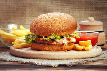 Sandwich burger with chicken meat, sauce and fries on table in rustic style - 692510032