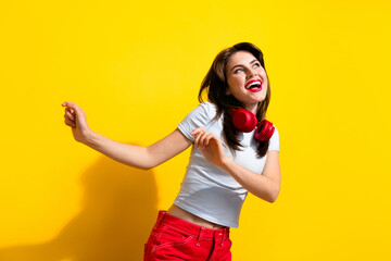 Photo of shiny cheerful lady wear white t-shirt earphones enjoying disco looking empty space isolated yellow color background