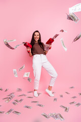 Full length vertical photo of cheerful pretty person hold money gun shooting flying banknotes...