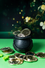 Happy St Patrick Day. Cauldron with gold coins and clovers on green background.