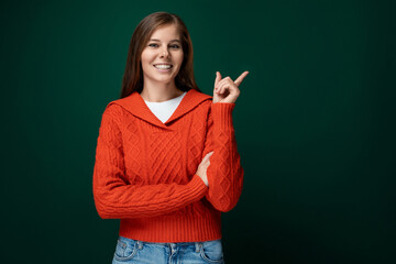 Joyful lucky woman wearing a red sweater on a dark green background