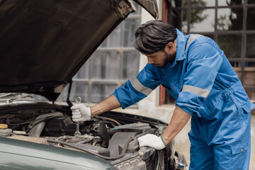 Fototapeta na wymiar car engine service concept Car mechanic checks car engine with car repair inspection, car service and maintenance, checks oil in car engine.