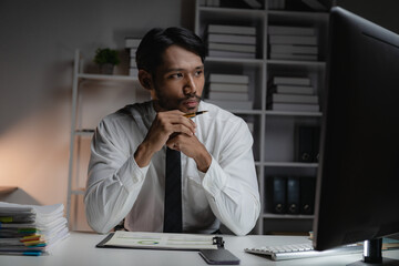 Black businessman planning paperwork and financial reports at desktop computer, young entrepreneur...