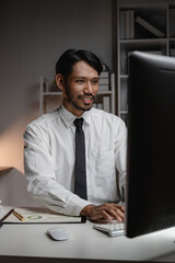 Black businessman planning paperwork and financial reports at desktop computer, young entrepreneur...