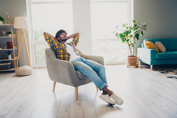 Photo of nice confident man boss sitting in soft armchair holding hands behind head enjoying relax...