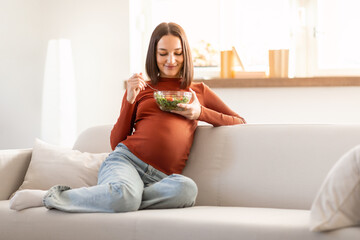 Glad Pregnant Woman Eating Fresh Veggie Salad At Modern Home