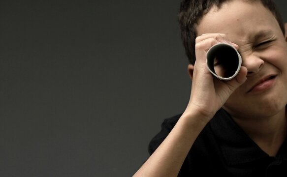 boy looking  through binoculars on grey background with people stock image stock photo