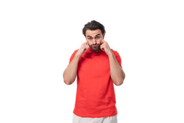 young brutal caucasian brunette man with a beard dressed in red clothes on a studio background with copy space