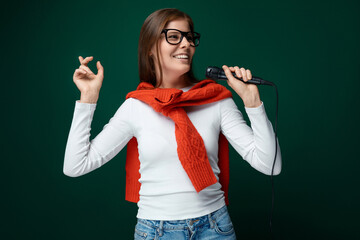Charming young woman with a microphone sings a karaoke song