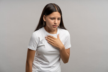 Sick unhealthy teenager feeling uncomfortable, touching chest, suffering from panting, difficult...