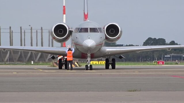 Private Business Corporate Executive Jet arriving at General Aviation Stands at airport with Marshaller