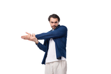 young brutal caucasian man with black hair is dressed in a blue shirt over a t-shirt