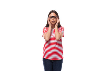 Obraz na płótnie Canvas young charming brunette woman with glasses dressed in a striped t-shirt covered her ears on a white background with copy space
