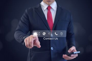 Businessman using a smartphone and touching on virtual screen contact icons (email, address, live chat, telephone). Concept of using internet technology to contact customers.
