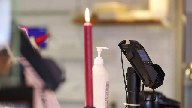 Stockholm, Sweden A credit card payment terminal and a candle.