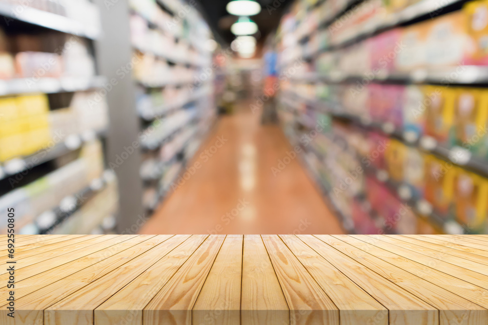 Wall mural empty wood table top with supermarket blurred background for product display