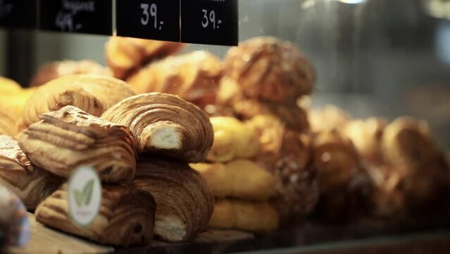 Stockholm, Sweden A server in a cafe fills a display case with sweet buns like cinnamon rolls and croissants. 