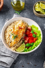 Fried catfish steak with rice and vegetable salad on a gray background vertical photo