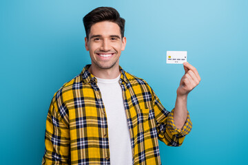 Photo of cheerful positive pleasant man with bristle dressed plaid shirt holding credit card in...