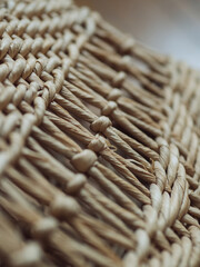 Vertical straight from above close up detail of a straw shoulder beach bag.