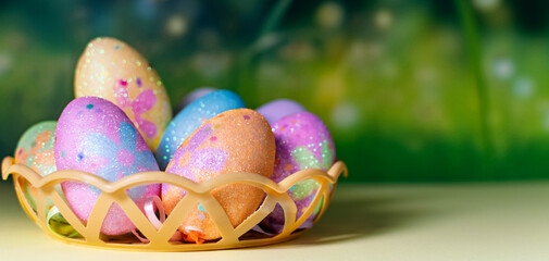 Happy Easter day decoration colorful eggs in nest on green background with copy space.