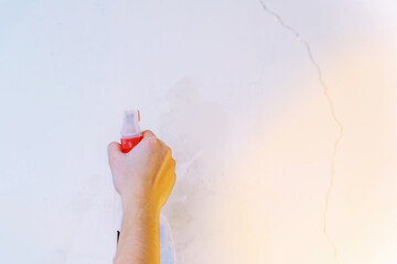 Worker spraying liquid on wall during repair