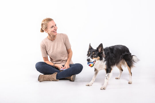 Middle-aged woman with a border collie dog on white background