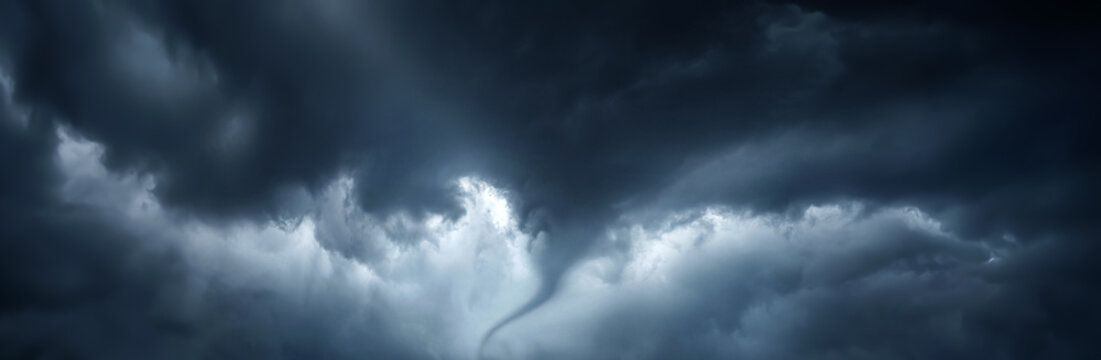 The typhoon is born, a tornado in a stormy dark sky with black clouds and a strong wind. Concept on the theme of weather, natural disasters, tornadoes, typhoons, tornadoes, thunderstorm.