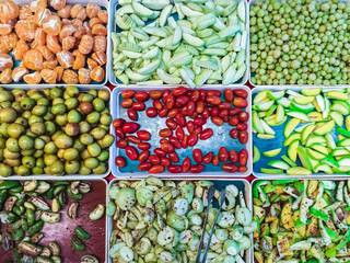 Top view of assorted fruits and pickled fruits on trays for sale in street market, healthy food concept Include high vitamin fruits, fresh fruits, Thai fruits, Street food.Variety fruits as background